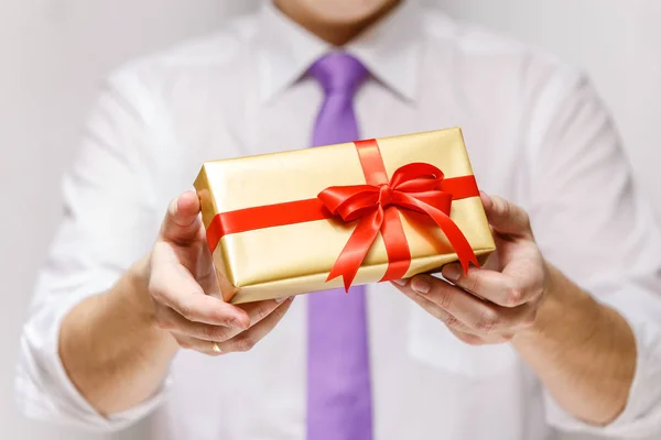 Male hands holding a gift box with ribbon. — Stock Photo, Image