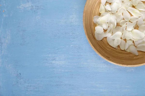 Mavi ahşap arka plan üzerinde beyaz gül yaprakları.