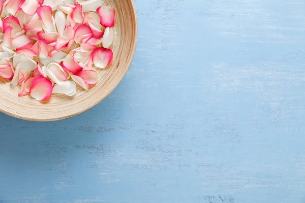 Mavi ahşap zemin üzerine gül yaprakları.