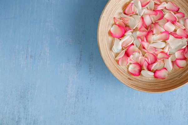 Mavi ahşap zemin üzerine gül yaprakları.