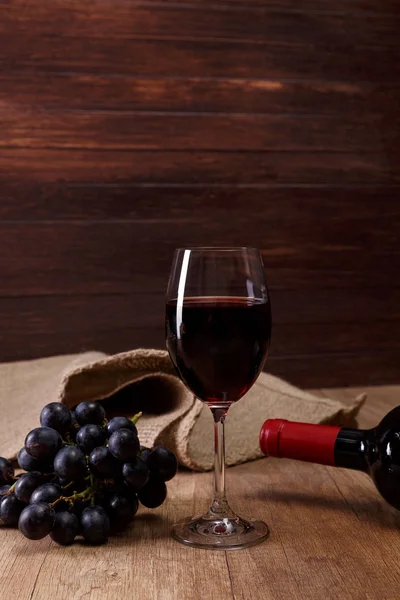 Kırmızı şarap. Bardağı üzüm şubesi ile.