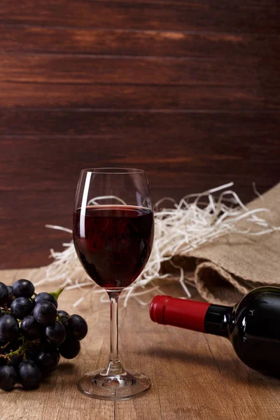 Kırmızı şarap. Bardağı üzüm şubesi ile.