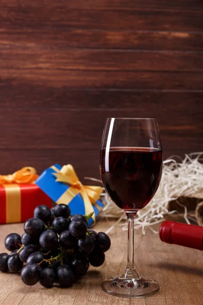 Kırmızı şarap. Bardağı üzüm şubesi ile. Hediye kutusu.