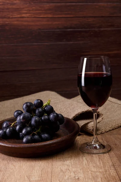 Red wine. Wineglass with grapes branch. Royalty Free Stock Images