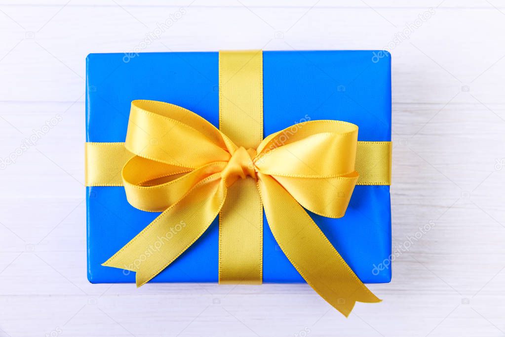 Gift box with yellow bow. Blue present package.