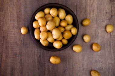 Ahşap masa üzerinde rustik bir tabak patates.