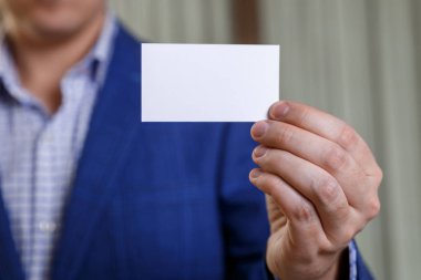 Ziyaret veya iş kartı tutan işadamı.