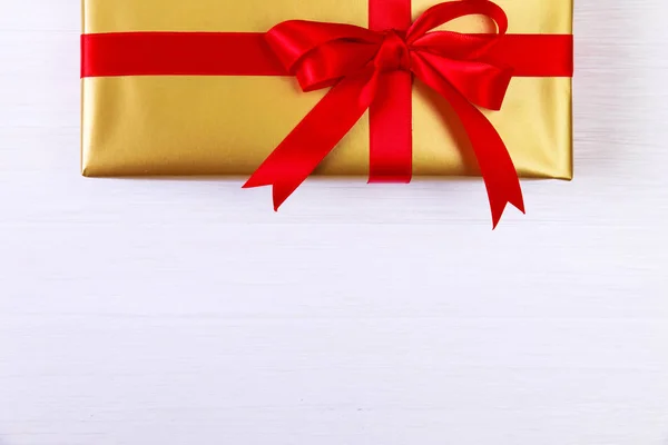 Подарочная коробка с красным бантом. Золотой подарок . — стоковое фото