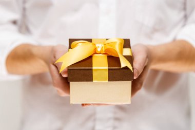 Bir hediye kutusu kurdele ile holding erkek eller.