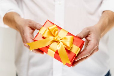 Kurdele ile bir kırmızı hediye kutusu holding erkek eller.