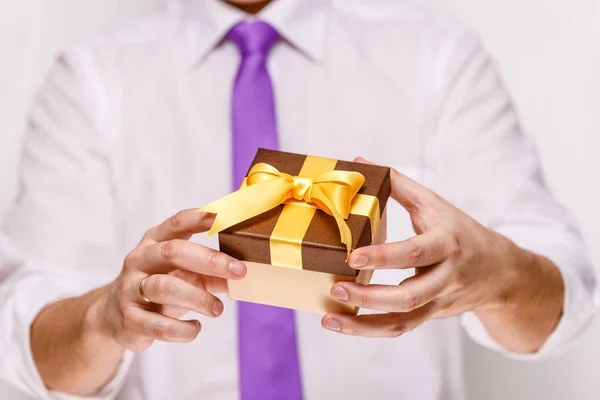 Male hands holding a gift box with ribbon. — Stock Photo, Image