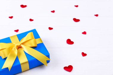 Hediye kutusu ile kırmızı kalpler. Mavi geçerli paketin.