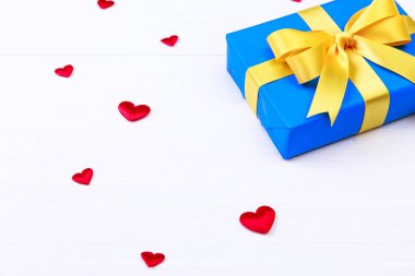 Hediye kutusu ile kırmızı kalpler. Mavi geçerli paketin.