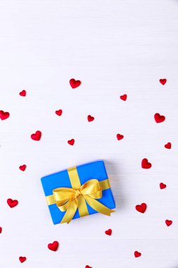 Hediye kutusu ile kırmızı kalpler. Mavi geçerli paketin.