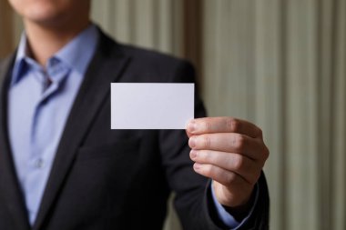 Ziyaret veya iş kartı tutan işadamı.