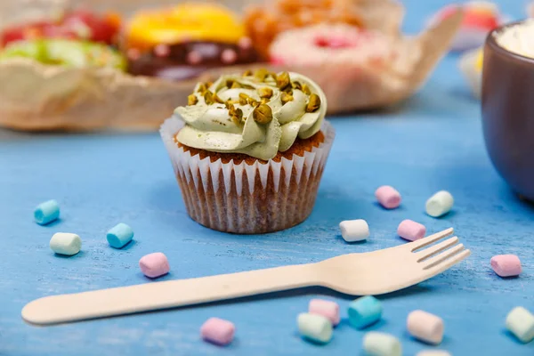 Cupcakes mit Buttercreme und Donuts. — Stockfoto