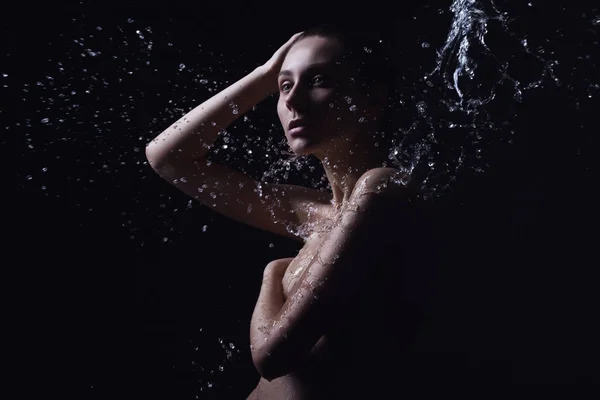 Ritratto di una bella giovane donna con spruzzi d'acqua — Foto Stock