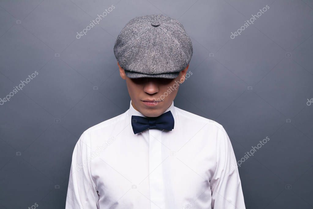 Mysterious portrait of retro 1920s english gangster with flat ca