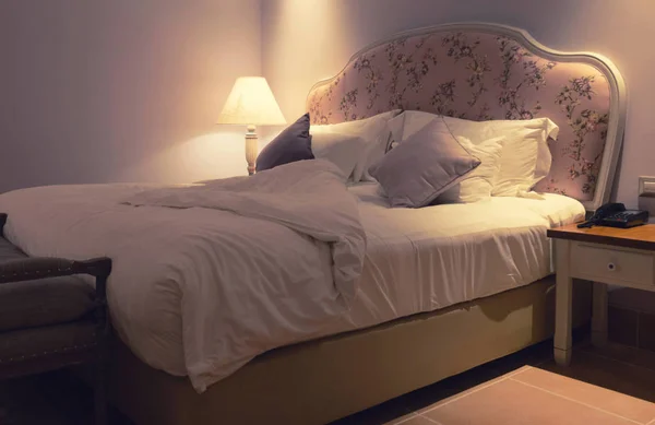 Неопрятная кровать в отеле ночью — стоковое фото