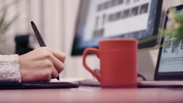 Жінка-дизайнер використовує свій графічний планшет на роботі — стокове відео