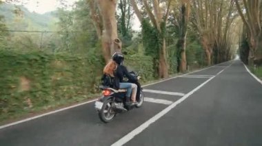 Genç heteroseksüel çift ülke yolda onların motosiklet sürmek. Arkadan vurdu.