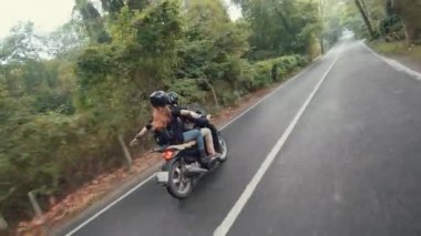 Scooter üzerinde erkek arkadaşı oturan genç kadın binici yükseltir ve sevinç ve özgürlüğü sembolize için silah yayılır