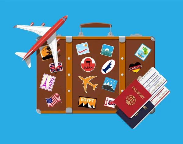 Reisekoffer mit Aufklebern und Flugzeugen — Stockvektor