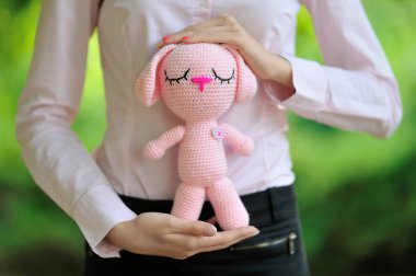 Pembe örgü tavşan amigurumi bir kız elinde