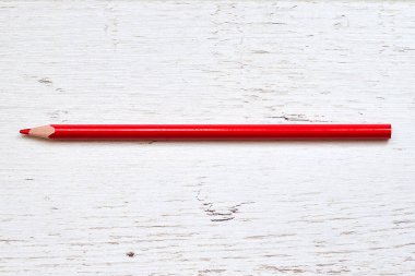 Ahşap arka plan üzerinde izole kırmızı kalem