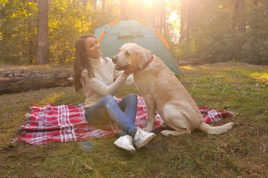 Kamp gezisinde çadırı olan köpeği olan bir kız..