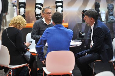 MEDICA Ticaret Fuarı, DÜSELDORF, GERMANY - Kasım 2019, mankenler üzerinde ortopedik korseler, Avrupalı erkekler Coronavirüs, COVID-19 hakkında konuştukları bir tıp konferansında.