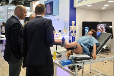 MEDICA Ticaret Fuarı, DÜZSELDORF, GERMANY - Kasım 2019, simülatör manken koltukta bir kadın doğuruyor..