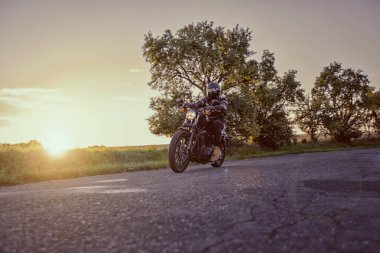 Yüksek güç motosiklet helikopter günbatımı sırasında.