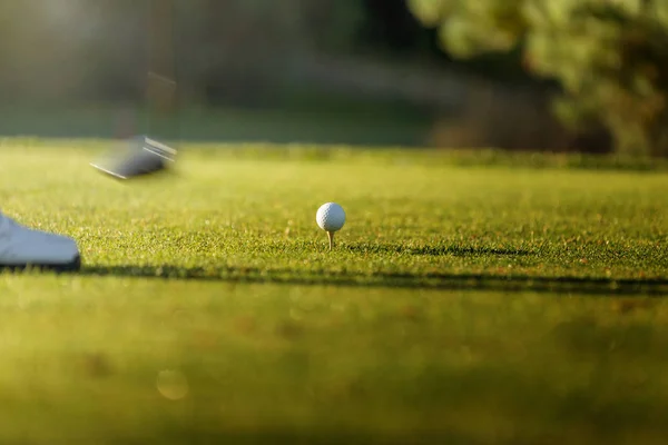 Golfista golpeando el palo de hierro en el campo de golf en fairway. Pelota de golf en tee . —  Fotos de Stock