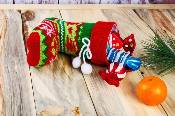 Sul tavolo è un calzino di Natale colorato con caramelle . — Foto Stock