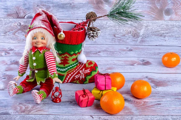Scena natalizia con elfo, calzini natalizi, mandarini e regali . — Foto Stock