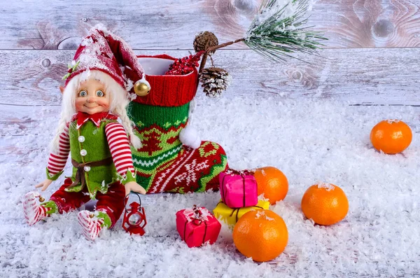 Scena natalizia con elfo, calzini natalizi, mandarini e regali . — Foto Stock