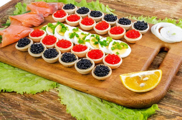 Tartlets with caviar, salted salmon and eggs. — Stock Photo, Image