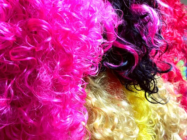 Multicolored background of wigs.