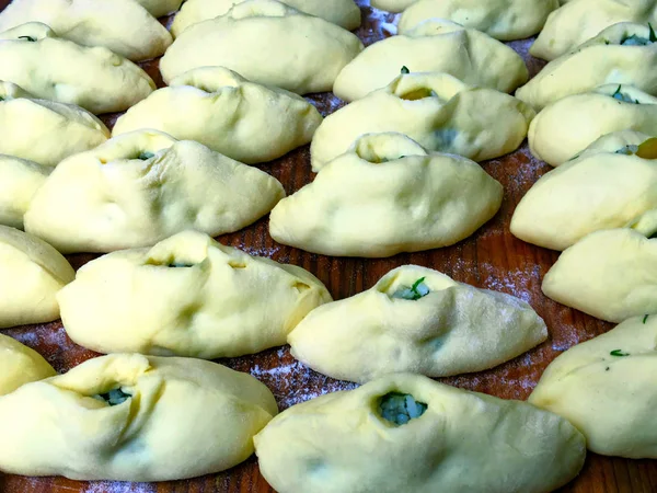 Pasteten auf einem Backblech, bevor sie in den Ofen kommen. rohe Torten. — Stockfoto
