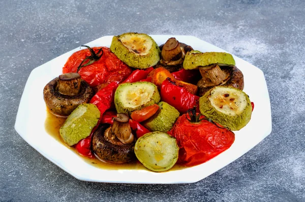Grilled vegetables in a white plate on a dark surface. — Stock Photo, Image