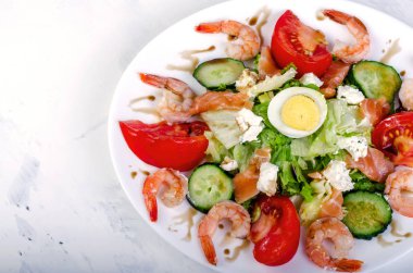 Sebze ve beyaz bir tabak karides salatası. Üzerinde hafif bir ba