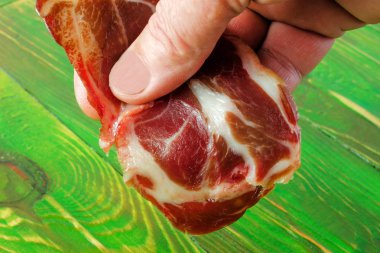 Erkekler el Serrano jambon dilim alıyor. Üzerinde ahşap bir yeşil adam