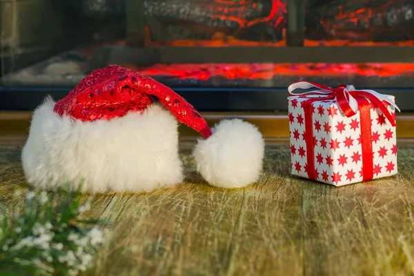 Santa cappello e regalo di Natale si trovano sulla superficie di legno vicino alla — Foto Stock