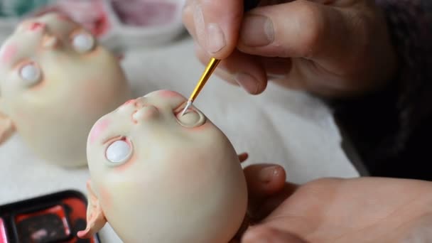 Master puppeteer draws eyes for dolls. — Stock Video