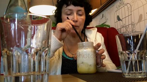乌克兰 2017年10月 成年妇女喝鸡尾酒通过吸管在咖啡馆 — 图库视频影像