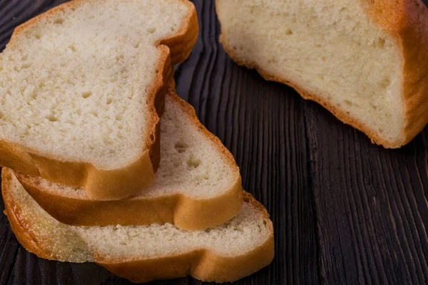 Beyaz koyu ahşap bir masa dilimlenmiş ekmek. — Stok fotoğraf