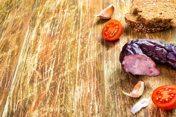 Geräucherte Schweinswurst mit Schwarzbrot, Tomaten und Knoblauch auf der — Stockfoto