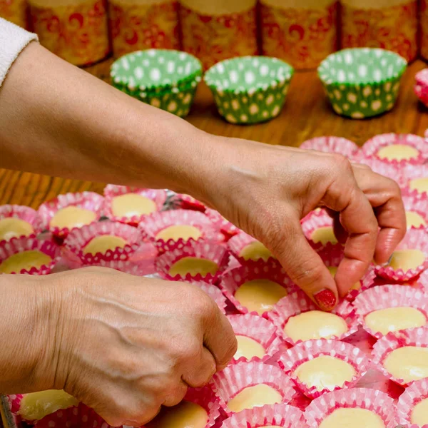 Cooking cupcakes in the form. Human's hand and dough in paper fo