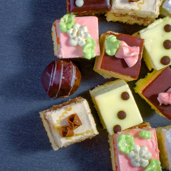 Assorted colorful natural sweet cakes on a black background. Cop